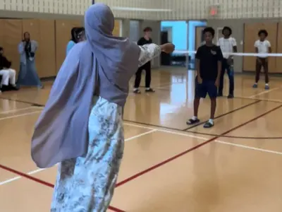 A young woman serves a volleyball during a game of volleyball