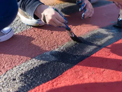 close up of a hand painting art on the road