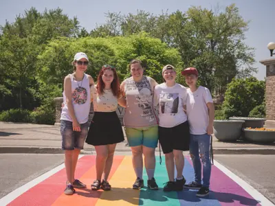 group of people standing on rainbow crosswalk