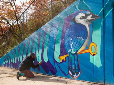 man spray painting art on a wall