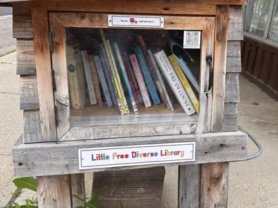 photo of a wooden little library with a sign Little Free Diverse Library
