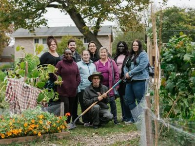 A group of gardeners posing for a photo at their community garden